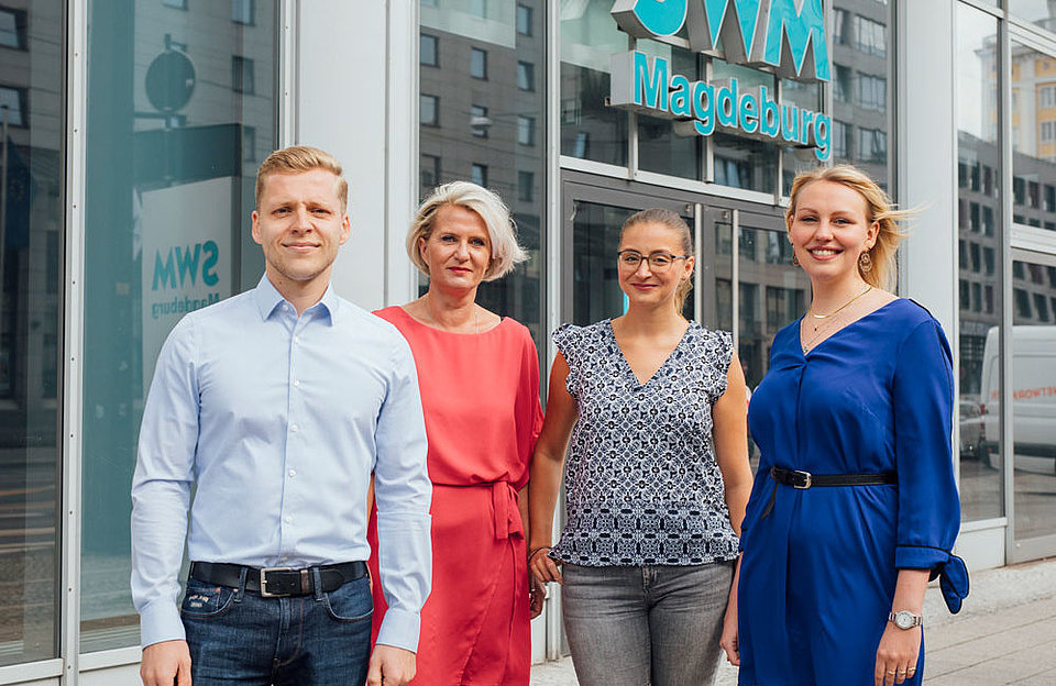 Ein Gruppenfoto von Mitarbeitern des SWM Kundenservice vor dem Kundencenter der SWM Magdeburg