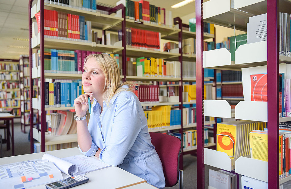 Duales Studium bei SWM Bibliothek Studentin der dualen Ausbilung bei SWM sitzt in der Bibliothek und lernt