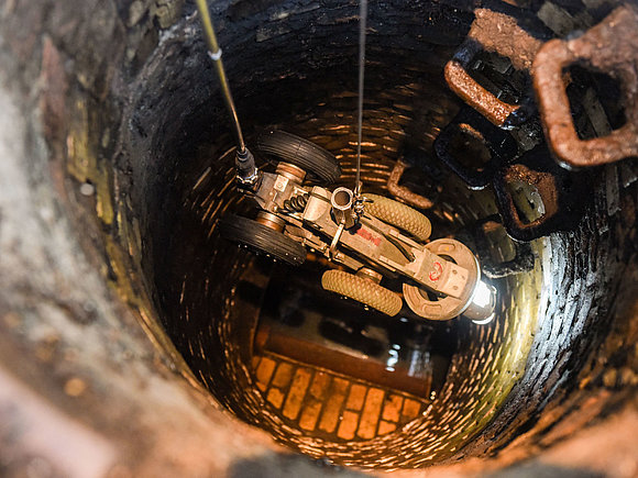 Kamera zur Abwasser-Kanalinspektion wird in den Kanal hinab gelassen