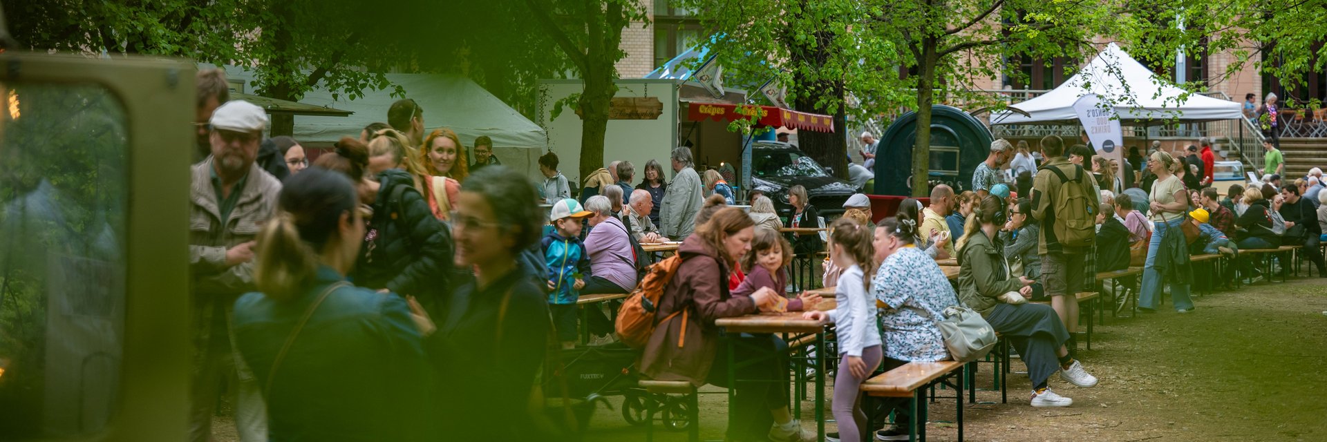 Besucher der Grünen Messe sitzen auf Bänken
