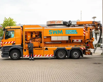 Auszubildender Umwelttechnologe steht vor deinem Hochdruckspülfahrzeug
