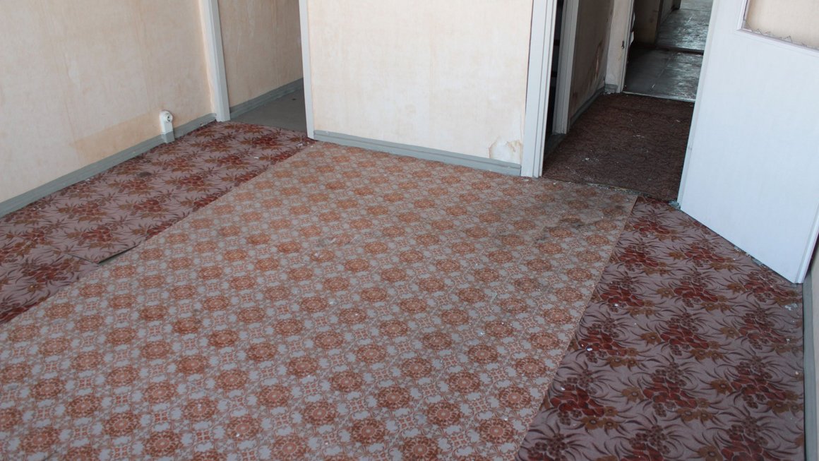 Blick auf den Fußboden mit Linoleum in einer Wohnung Alte Blümchentapete im alten Blauen Bock