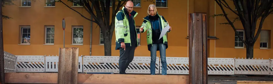 Zwei Mitarbeiter stehen an einer Baustelle für Trinkwasserleitungen