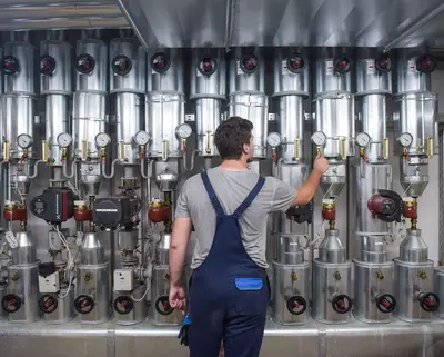 SWM Azubi Anlagenmechaniker mit dem Rücken zum Kamera bei Arbeit