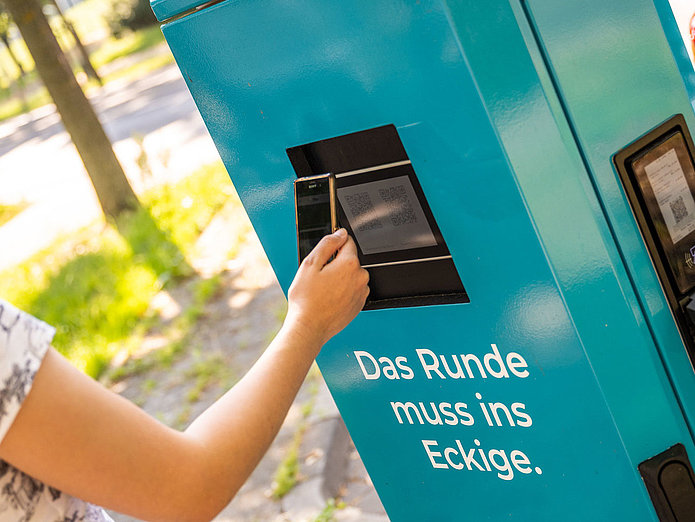 Zahlen an der E-Ladesäule Junge Frau zahlt per SMS an einer SWM E-Ladesäule