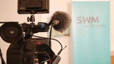 Eine Kamera steht für ein Interview vor einem SWM Banner