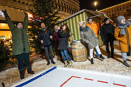 Gruppe beim Eisstockschießen auf dem SWM Weihnachtsmarkt