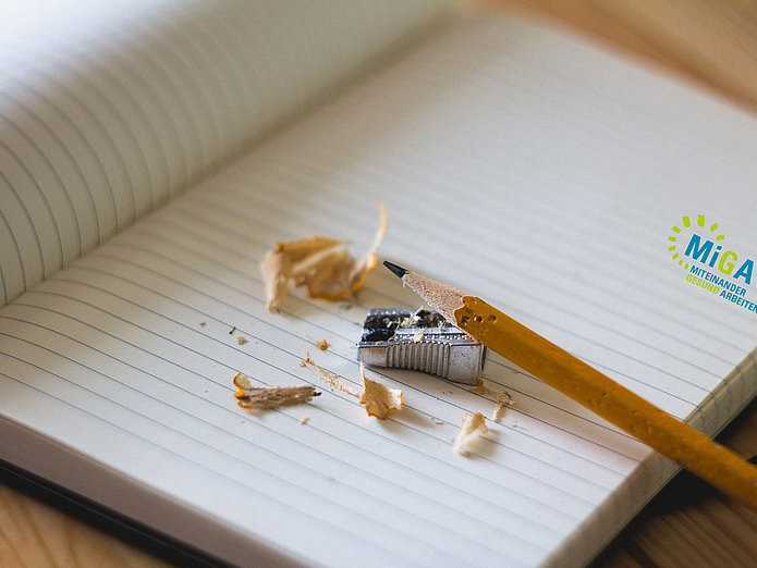 Weiterbildung bei SWM Notizbuch mit Bleistift und Anspitzer und MiGA-Logo von SWM