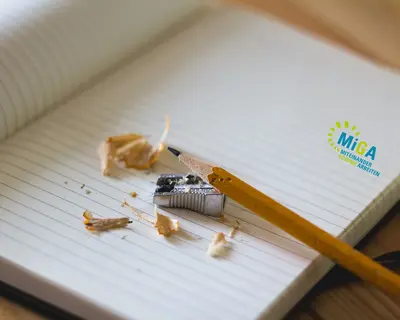 Notizbuch mit Bleistift und Anspitzer und MiGA-Logo von SWM