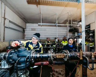 Spezialmonteur Mike Kaufmann (l.) von den SWM Magdeburg legt letzte Hand bei der Inbetriebnahme der Energiezentrale der Uni an. Ab heute wird der Campus mit klimaneutraler Fernwärme versorgt.