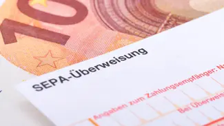 Bild mit SEPA-Überweisung und 10-Euro-Schein im Hintergrund