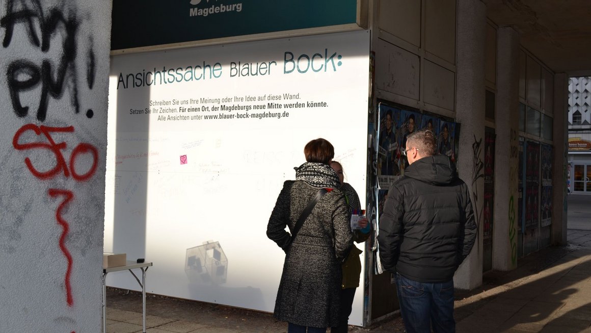 Passanten lesen Plakat mit Meinungen am alten Blauen Bock zur Meile der Demokratie