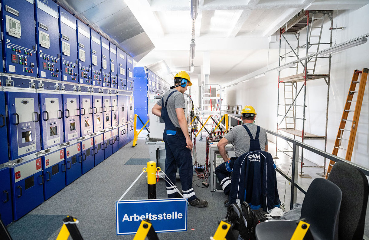 Zwei SWM Mitarbeiter arbeiten an der Wartung eines Leistungsschalters