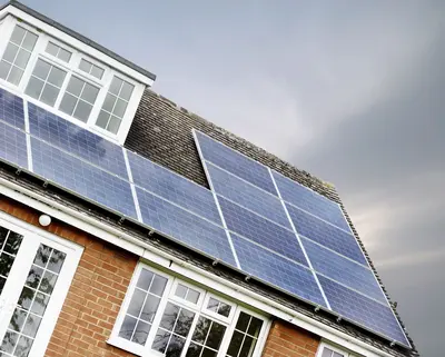 PV Anlange auf einem Haus mit dunklem Himmel im Hintergrund