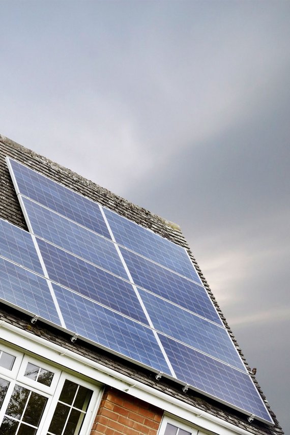 PV Anlange auf einem Haus mit dunklem Himmel im Hintergrund