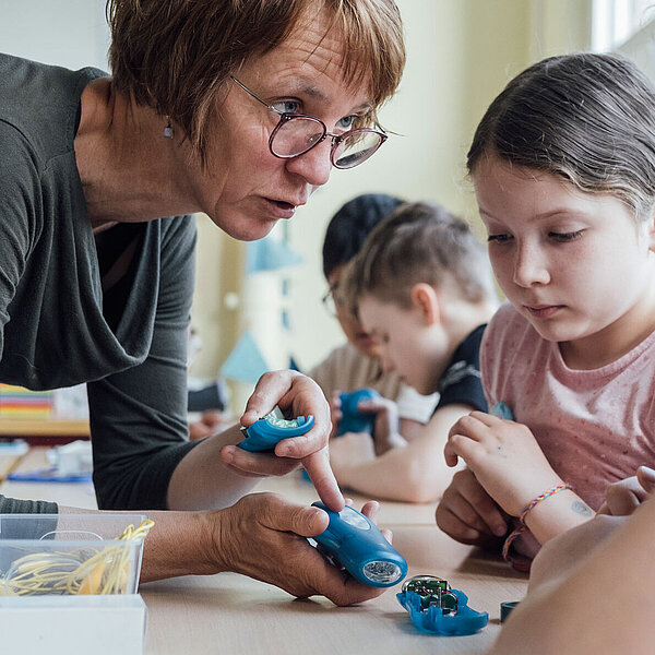 BlitzKitz-Lehrerin erklärt Schüler:innen eine Dynamo-Taschenlampe