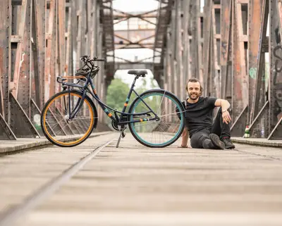 junger Mann sitzt neben trittfest Rad mike auf der Hubbrücke