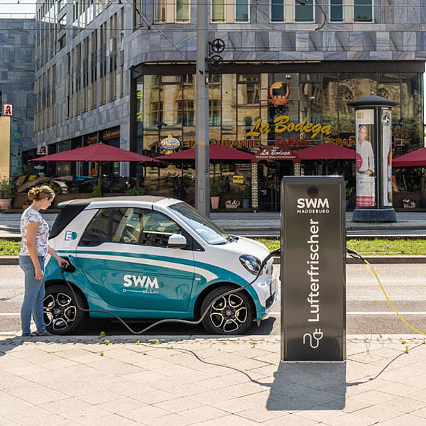 Frau lädt an Ladesäule in Magdeburger Innenstadt.