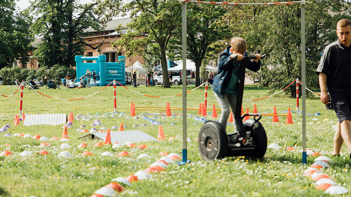 Kind fährt auf der Grünen Messe mit einem Segway einen Parcours