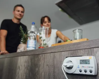 Familie in der Küche mit Strommessgerät