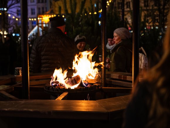 Gemütlichkeit auf dem SWM Weihnachtsmarkt Menschen stehen um eine Feuertonne auf einem Weihnachtsmarkt