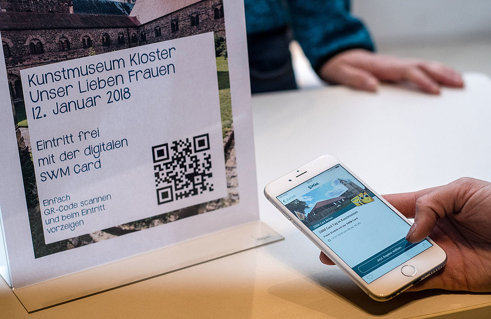 Aktionen in der SWM App Aufsteller und Handy mit Hinweis auf eine Aktion in der SWM App