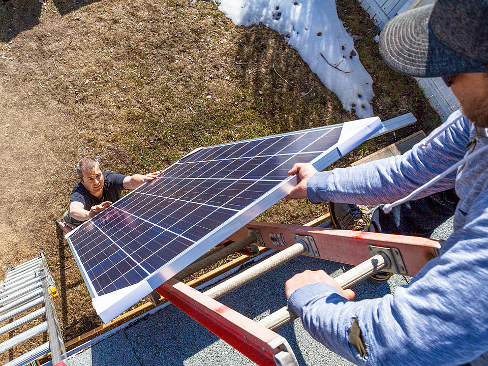Solarpanel Solarpanel wird auf Dach gehoben