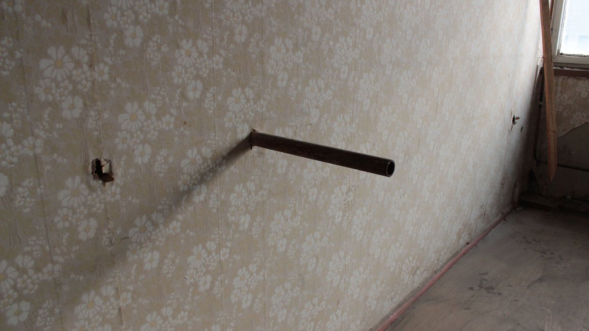 Tapezierte alte Wand mit Metallstange im alten Blauen Bock