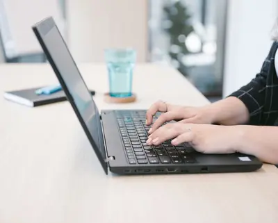 Zwei Hände auf einem Laptop