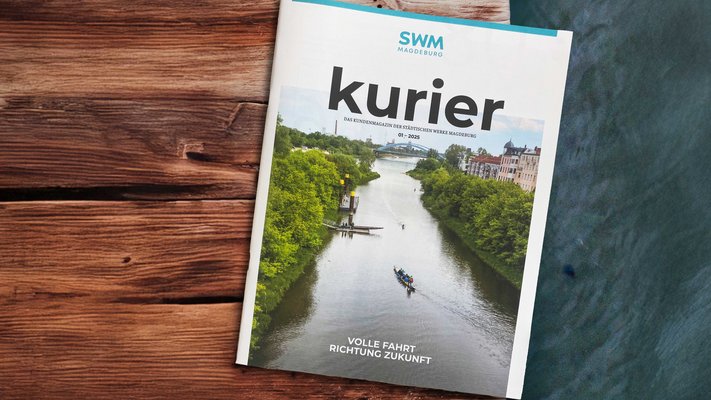 SWM Kundenmagazin Kurier liegt auf einem Holzsteg