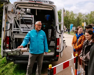SWM Mitarbeiter erklärt Kunden die Kanal-TV-Kamera