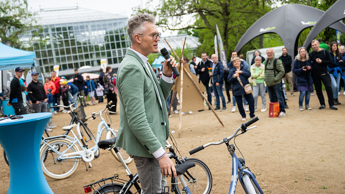 Mann moderiert Fahrradversteigerung