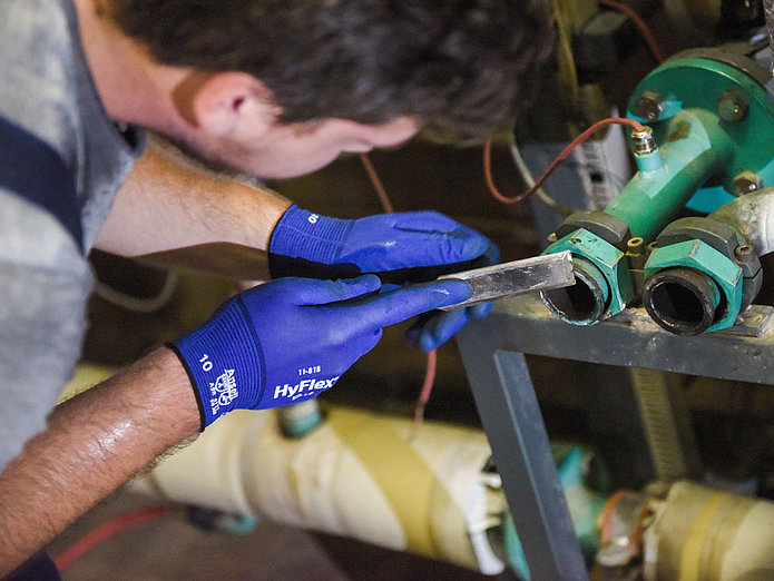 Ausbildung zum Anlagenmechniker/in bei SWM Azubi zum Anlagenmechaniker mit Feile in der Hand bei der Arbeit
