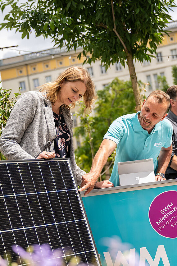 SWM PV-Experte und Energieberater beraten zwei Kundinnen in Nachbars Garten