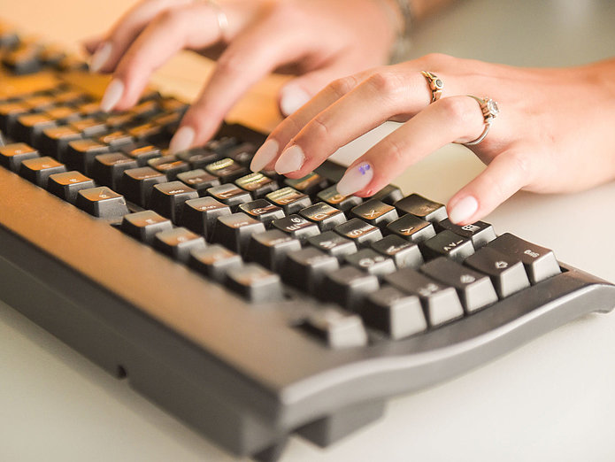 Studentin der dualen Ausbildung bei SWM schreibt auf Tastatur