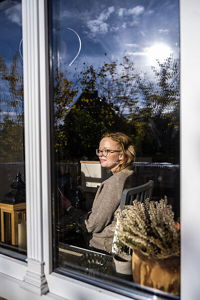 Frau sieht entspannt aus dem Fenster