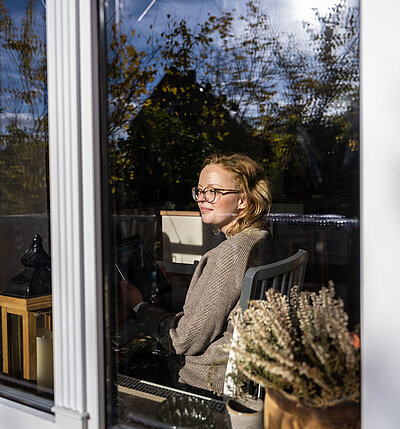 Frau sieht entspannt aus dem Fenster