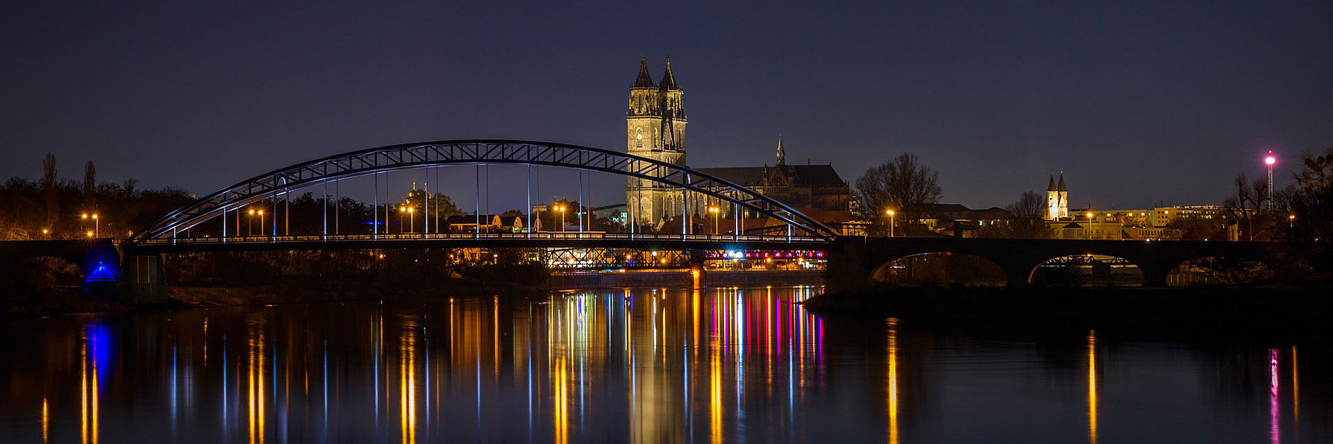 Magdeburg bei Nacht mit Elbe im Vordergrund