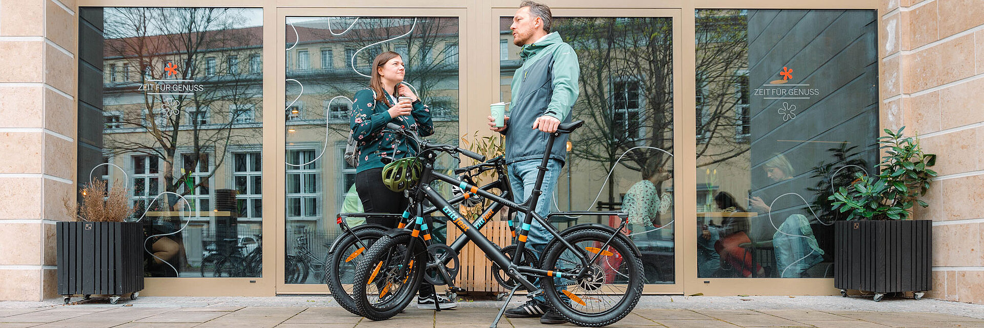 Zwei Radfahrer:innen stehen neben zwei E-Bikes E.mil 