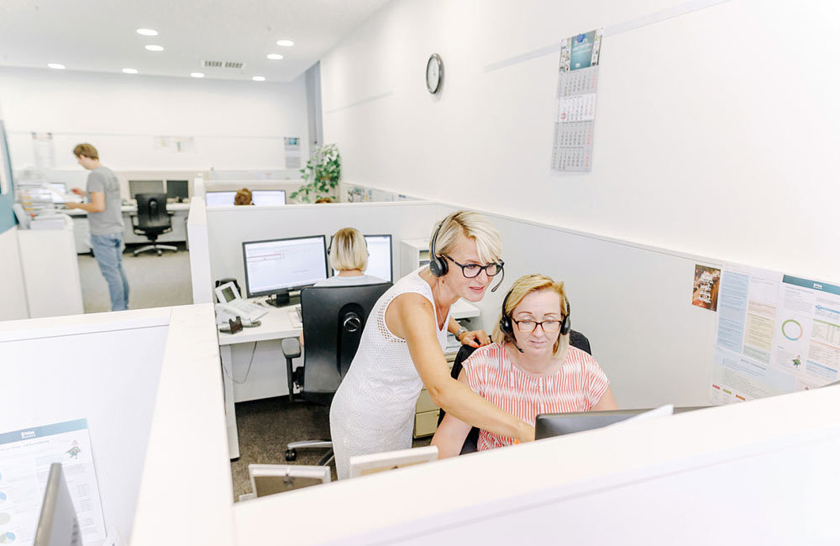 SWM Mitarbeiter im Callcenter Eine SWM Mitarbeiterin zweig einer Kollegin im Callcenter etwas am Bildschirm