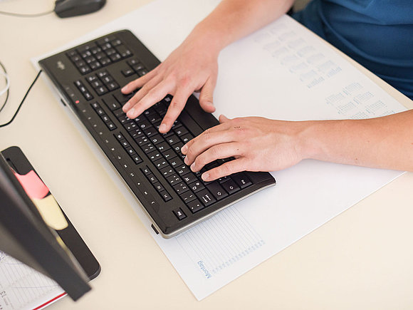 Computerarbeit SWM Azubi schreibt auf der Computer-Tastatur
