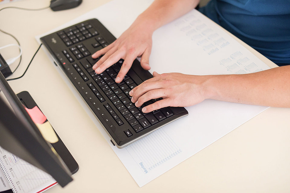 SWM Azubi schreibt auf der Computer-Tastatur