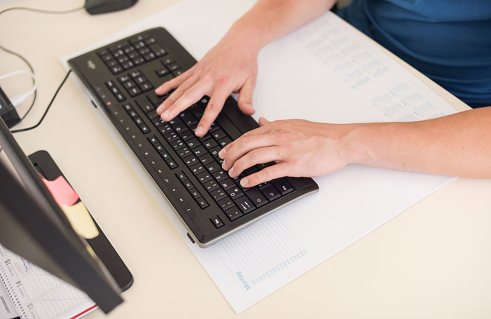 Computerarbeit SWM Azubi schreibt auf der Computer-Tastatur