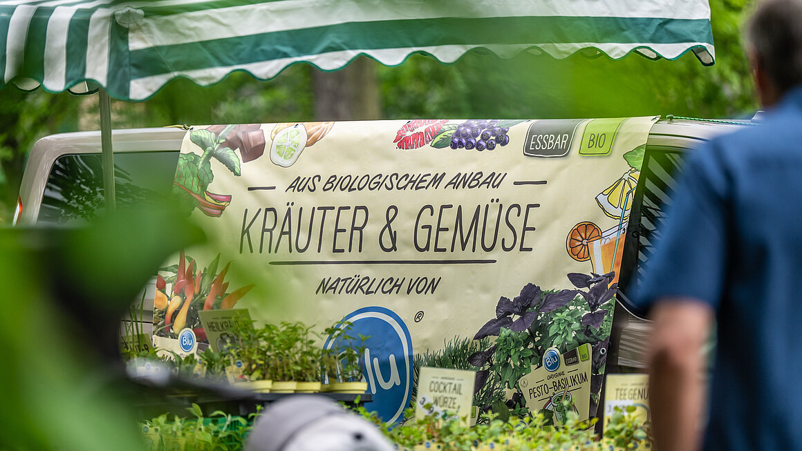 Blick auf einen Stand mit Banner "Kräuter und Gemüse"