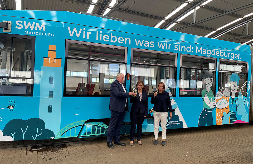 SWM Geschäsftführer Herr Herdt, Marketingleiterin der SWM Frau Beyer und MVB Geschäftsführerin Frau Münster-Rendel stehen vor der neuen SWM Straßenbahn