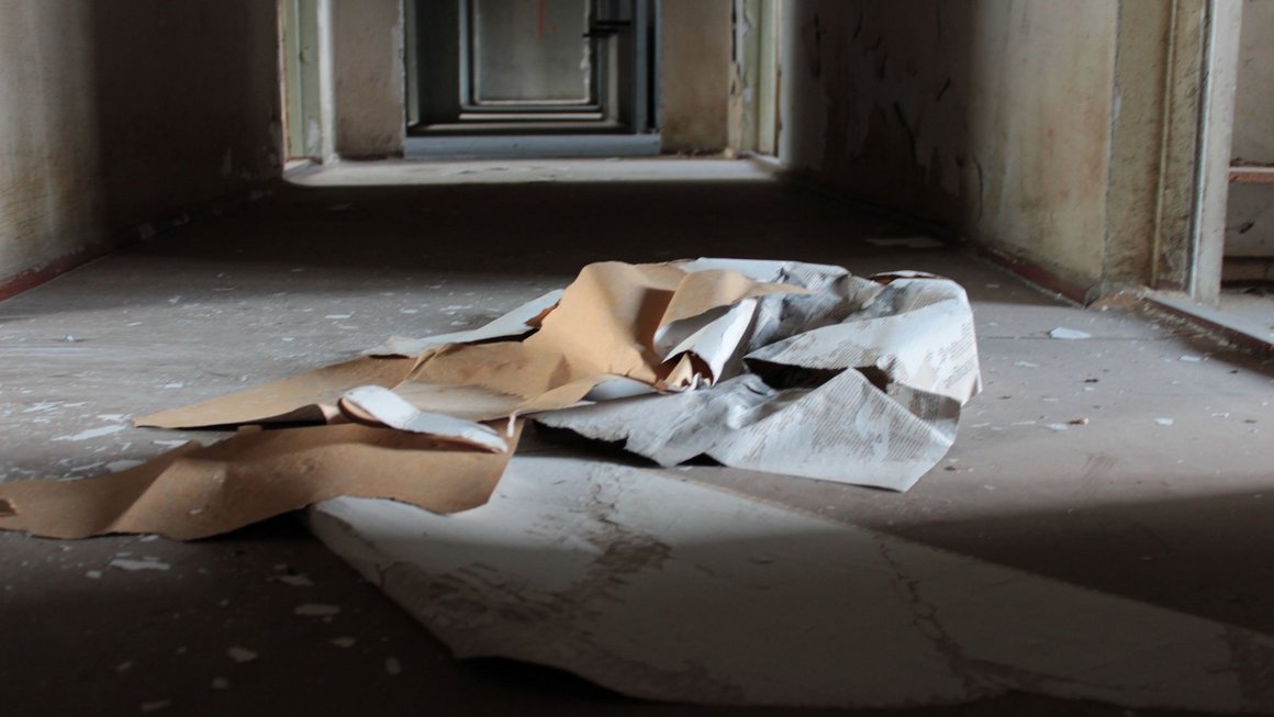 Blick in einen leeren Flur mit abgerissener Tapete auf dem Boden im alten Blauen Bock