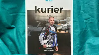 SWM Kundenmagazin Kurier 01/2026 liegt auf türkiser Ballonseide