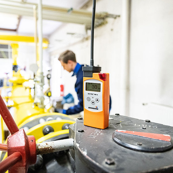 Ein Messgerät steht in der Gasdruckregelstation. Im Hintergrund ist ein SWM Mitarbeiter zu sehen.