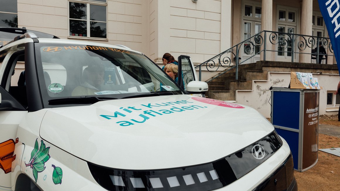 Familie schaut sich Elektroauto im SWM Design an