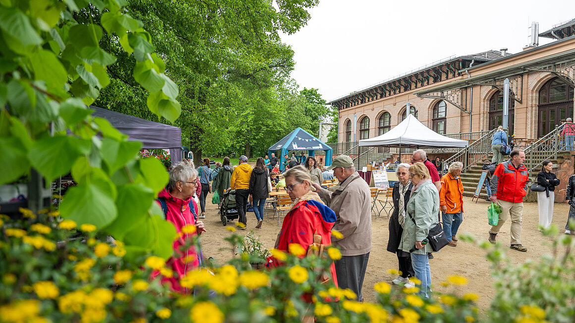 Besucher schlendern über Grüne Messe vorbei am Gesellschaftshaus
